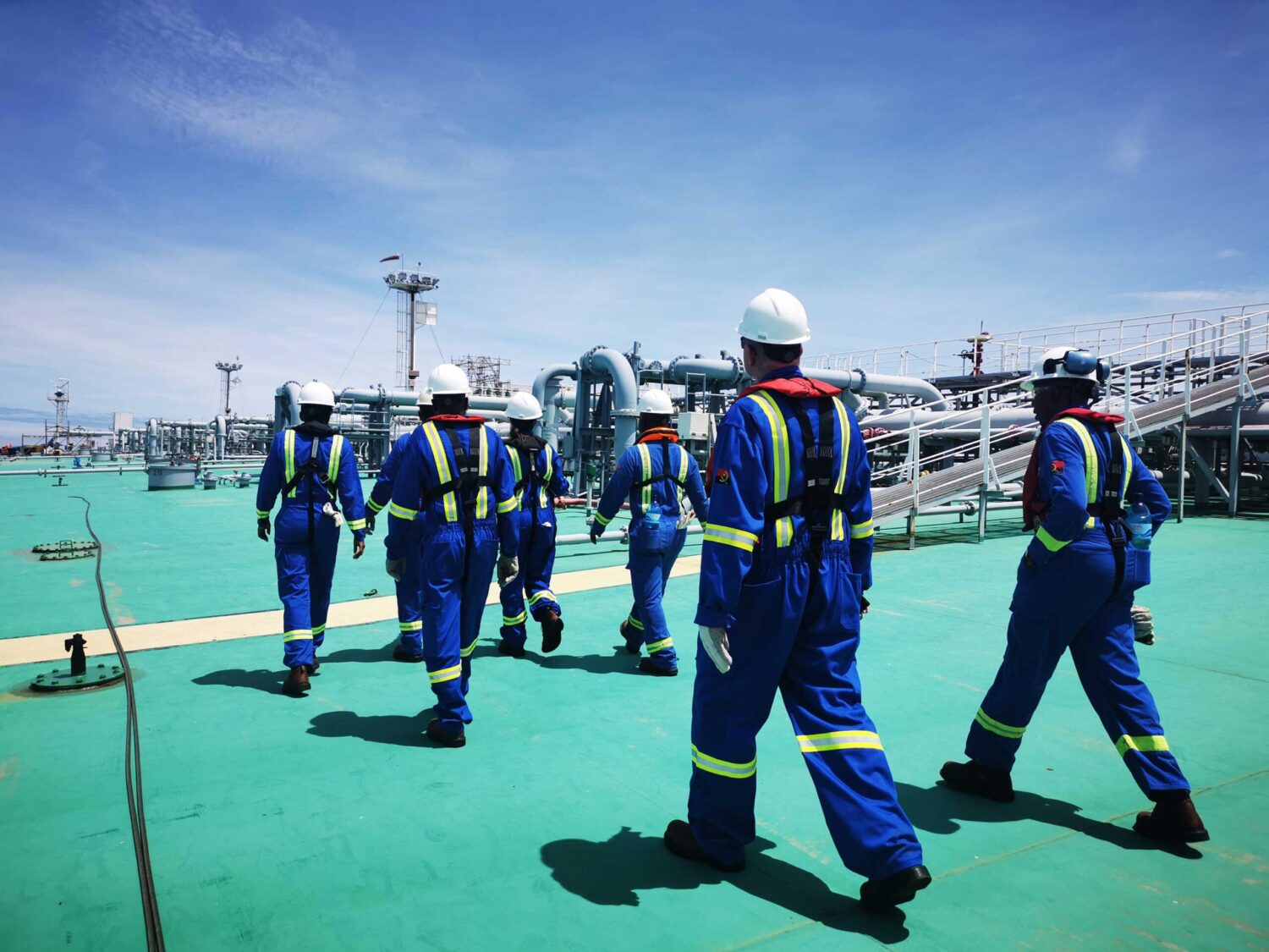 Workers walking across a tanker